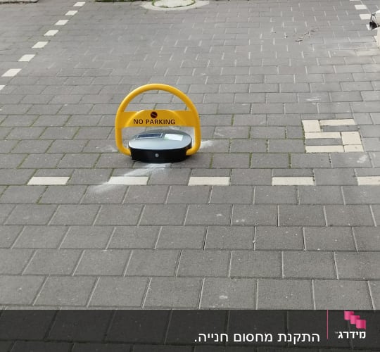 מחסום חניה צהוב עם כיתוב 